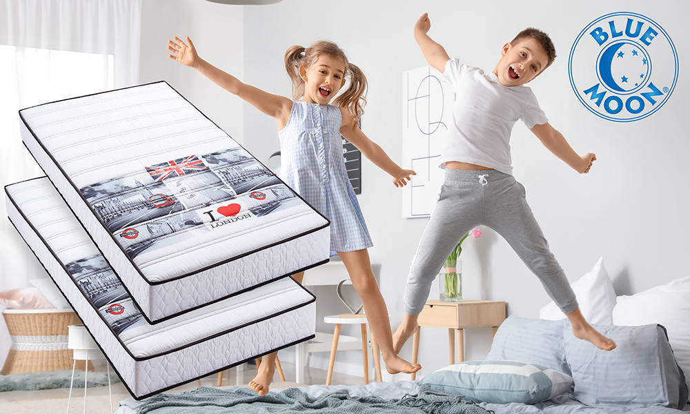 Happy children having fun in bedroom at home with two mattresses