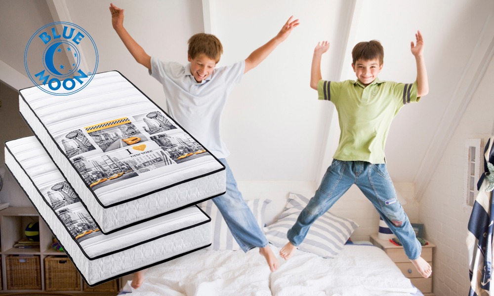 Mattresses with New York print and two boys jumping on a bed
